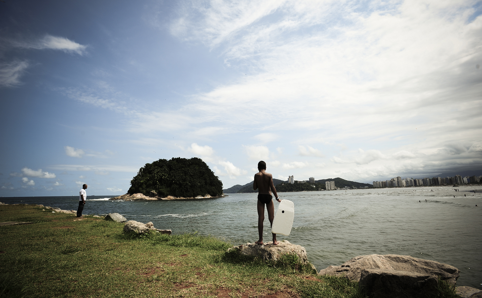 Menino observa as ondas com sua prancha de bodyboard na Praia de Jos&eacute; Menino