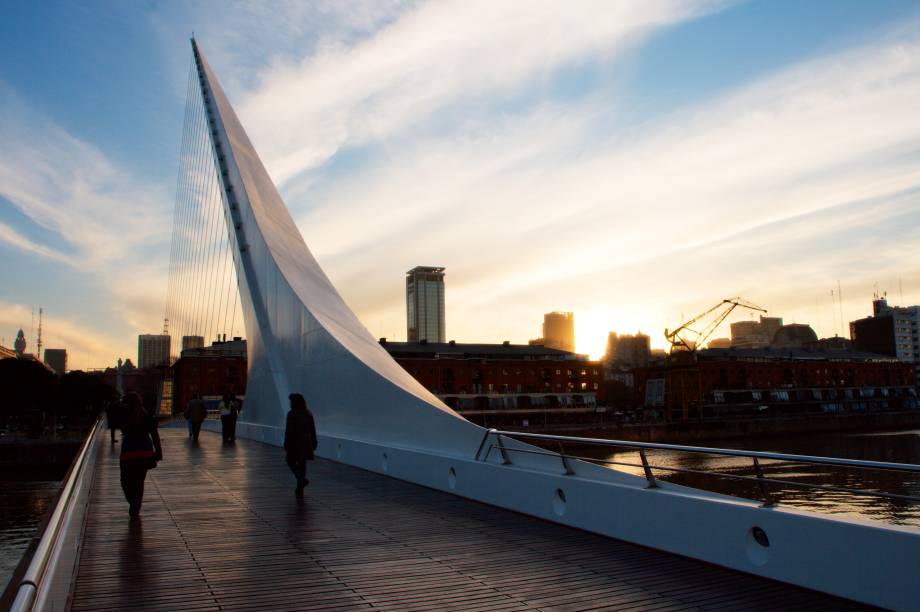 <strong>Puente de la Mujer </strong>                                    Localizada no delicioso bairro de Puerto Madero, a ponte é nada menos que um ponto turístico obrigatório na cidade, sendo considerada um dos grandes símbolos da capital argentina. Sua arquitetura peculiar tem uma razão de ser: dizem que ela imita a imagem de uma mulher dançando tango. Vale a pena fazer uma pausa durante a noite, quando o lugar fica ainda mais bonito