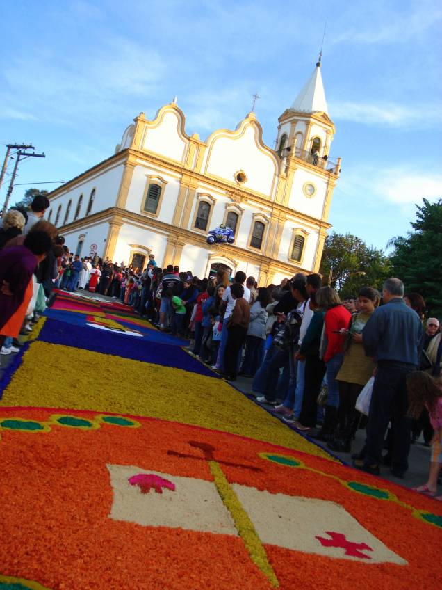 <a href="https://viajeaqui.abril.com.br/destinos/santana-de-parnaiba" rel="Santana de Parnaíba (SP)" target="_blank"><strong>Santana de Parnaíba (SP)</strong></a>O tapete artesanal da cidade é um dos mais famosos do estado: são 850 metros de extensão montados nas ruas do Centro Histórico. A arte percorre o Largo da Matriz, a Rua Suzana Dias, o Largo São Bento, a Rua Santa Cruz, a Rua Bartolomeu Bueno, a Praça 14 de Novembro, a Praça da Bandeira e a Rua Padre Miguel Mauro.A montagem dos tapetes começa bem cedo, às 6 horas da manhã do dia 7. Os sacos de serragem são tingidos com 11 cores diferentes pelos funcionários da Oficina Cultural e os moradores locais ficam responsáveis pela criação dos desenhos – os quadros sempre seguem uma ordem certa previamente planejada, inspirada na Campanha da Fraternidade <a href="https://viajeaqui.abril.com.br/destinos/santana-de-parnaiba" rel="Santana de Parnaíba (SP)" target="_blank"><strong>Santana de Parnaíba (SP)</strong></a>O tapete artesanal da cidade é um dos mais famosos do estado: são 850 metros de extensão montados nas ruas do Centro Histórico. A arte percorre o Largo da Matriz, a Rua Suzana Dias, o Largo São Bento, a Rua Santa Cruz, a Rua Bartolomeu Bueno, a Praça 14 de Novembro, a Praça da Bandeira e a Rua Padre Miguel Mauro.A montagem dos tapetes começa bem cedo, às 6 horas da manhã do dia 7. Os sacos de serragem são tingidos com 11 cores diferentes pelos funcionários da Oficina Cultural e os moradores locais ficam responsáveis pela criação dos desenhos – os quadros sempre seguem uma ordem certa previamente planejada, inspirada na Campanha da Fraternidade