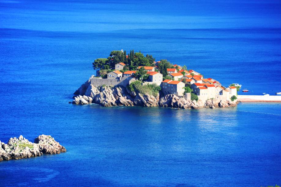 <strong>Sveti Stefan, Budva, Montenegro</strong>        São menos de quinze quilômetros que separam Budva dessa bela ilha, que também dá nome a um resort. A visão de belas montanhas conduz o caminho até o lugar, extremamente calmo e demarcado por águas cristalinas        <em><a href="https://www.booking.com/city/me/sveti-stefan.pt-br.html?sid=5b28d827ef00573fdd3b49a282e323ef;dcid=4aid=332455&label=viagemabril-as-mais-belas-praias-do-mediterraneo" rel="Veja preços de hotéis em Sveti Stefan no Booking.com" target="_blank">Veja preços de hotéis em Sveti Stefan no Booking.com</a></em>