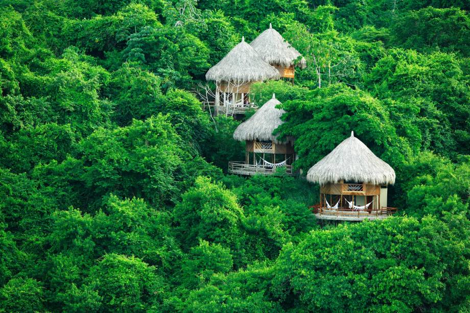 <strong>Parque Nacional Tayrona, Colômbia</strong>Em meio à vegetação do Parque Nacional Tayrona, encontram-se os Ecohabs, meios de hospedagem integrados à natureza na região de <strong>Santa Marta</strong>, na <strong><a href="https://viajeaqui.abril.com.br/paises/colombia" rel="Colômbia" target="_blank">Colômbia</a></strong>. O cenário é único no mundo: ali também está a Sierra Nevada de Santa Marta, cadeia montanhosa que alcança os 5.775 metros sobre o nível do mar e fica a apenas 42 quilômetros de praias banhadas pelo Mar do Caribe, o que faz dela a cordilheira costeira mais alta do planeta