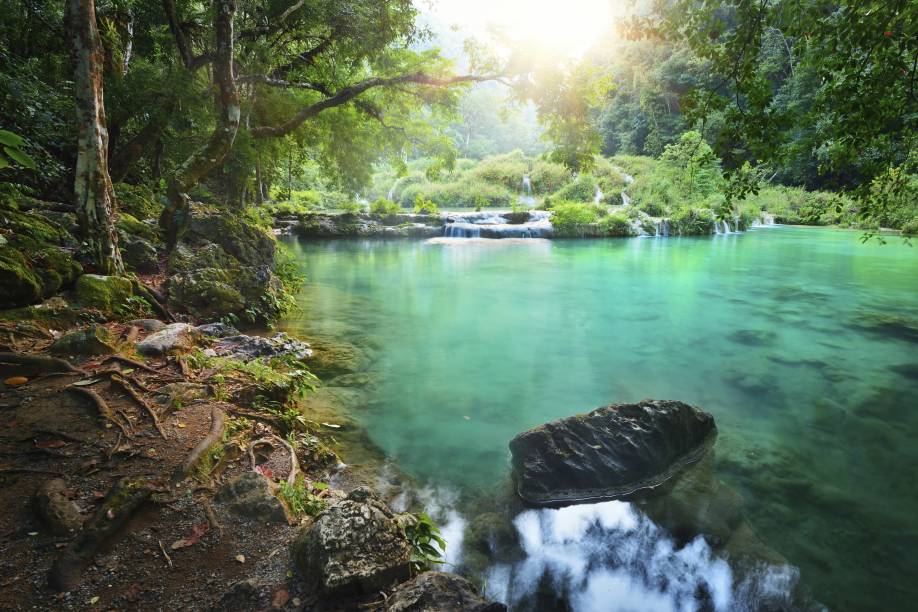 Por do sol na exuberante reserva natural de Semuc Champey, no centro da <a href="https://viajeaqui.abril.com.br/paises/guatemala" rel="Guatemala">Guatemala</a>; para chegar lá e admirar as piscinas naturais do lugar, você pode comprar um passeio em um veículo 4x4