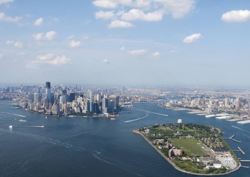 Vista aérea de <a href="https://viajeaqui.abril.com.br/cidades/estados-unidos-nova-york" rel="Nova York" target="_blank">Nova York</a> e a Governors Island a frente Vista aérea de <a href="https://viajeaqui.abril.com.br/cidades/estados-unidos-nova-york" rel="Nova York" target="_blank">Nova York</a> e a Governors Island a frente