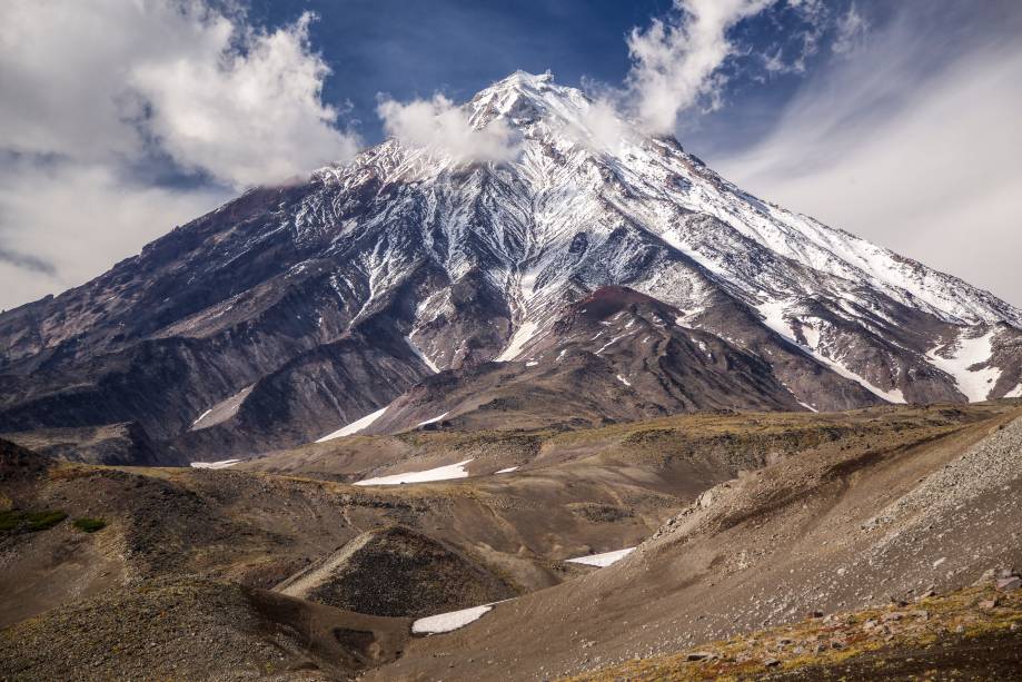 <strong>Koryaksky, Península de Kamchatka</strong>        O vulcão marca presença mesmo visto de longe. O formato bem regular, simétrico e elegante de sua encosta agrega ainda mais a sua beleza de 3 mil metros de altura. A erosão natural formou vales em que a neve se acumula e forma belos desenhos em sua superfície. Ele ainda faz parte do famoso Círculo de fogo do Pacífico, uma região onde se localiza vários vulcões e placas tectônicas que frequentemente se chocam e produzem terremotos