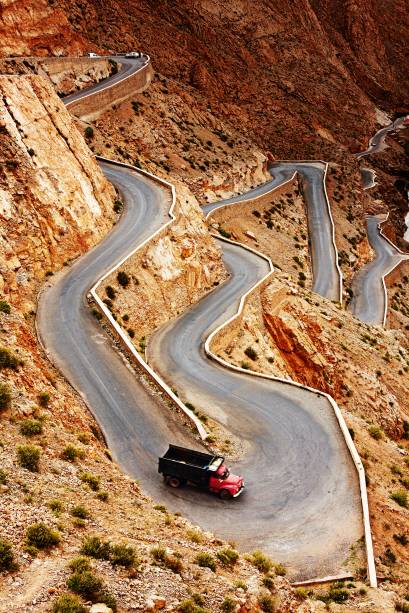 Taí um jeito acidentadíssimo de ir de um ponto a outro. A estrada das "mil kasbahs" (fortalezas antigas) sobe a Garganta Dades, um cânion de cinema na cordilheira Atlas, no <a href="https://viajeaqui.abril.com.br/paises/marrocos" target="_blank">Marrocos</a>. É um estonteante zigue-zague ribanceira acima. As curvas, radicais, vão cortando um ambiente desértico, daqueles de levantar poeira. E o caminho vai passando por aldeias dos povos berberes e bosques de palmeiras. Lindo, diferentão. E, é, meio perigoso Taí um jeito acidentadíssimo de ir de um ponto a outro. A estrada das "mil kasbahs" (fortalezas antigas) sobe a Garganta Dades, um cânion de cinema na cordilheira Atlas, no <a href="https://viajeaqui.abril.com.br/paises/marrocos" target="_blank">Marrocos</a>. É um estonteante zigue-zague ribanceira acima. As curvas, radicais, vão cortando um ambiente desértico, daqueles de levantar poeira. E o caminho vai passando por aldeias dos povos berberes e bosques de palmeiras. Lindo, diferentão. E, é, meio perigoso