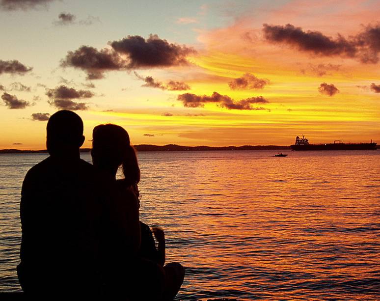 Jovem casal contempla o p&ocirc;r do sol no <a href="https://viajeaqui.abril.com.br/estabelecimentos/br-ba-salvador-atracao-museu-de-arte-moderna-solar-do-unhao" rel="Solar do Unh&atilde;o" target="_self">Solar do Unh&atilde;o</a>, <a href="https://viajeaqui.abril.com.br/cidades/br-ba-salvador" rel="Salvador" target="_self">Salvador</a>, <a href="https://viajeaqui.abril.com.br/estados/br-bahia" rel="Bahia" target="_self">Bahia</a>