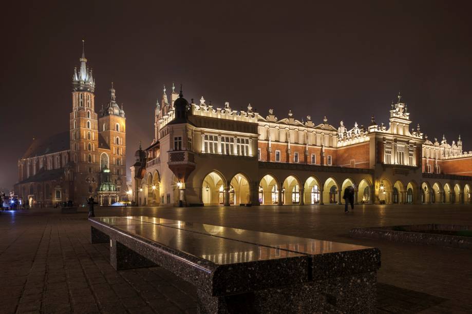 Praça do Mercado de Cracóvia, com a Basílica de Santa Maria à esquerda e o Sukiennice em primeiro plano, um edifício hoje ocupado por várias lojinhas de suvenires 