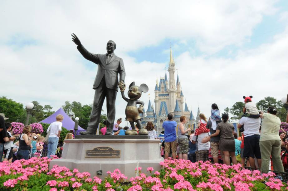 Estátua de Walt Disney com o Mickey Mouse e o Castelo da Cinderela, ao fundo, no parque temático Magic Kingdom Estátua de Walt Disney com o Mickey Mouse e o Castelo da Cinderela, ao fundo, no parque temático Magic Kingdom