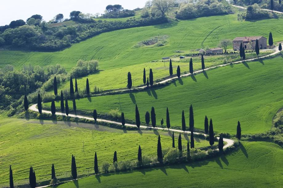 Típica paisagem rural da Toscana, com ciprestes e casas de tijolo