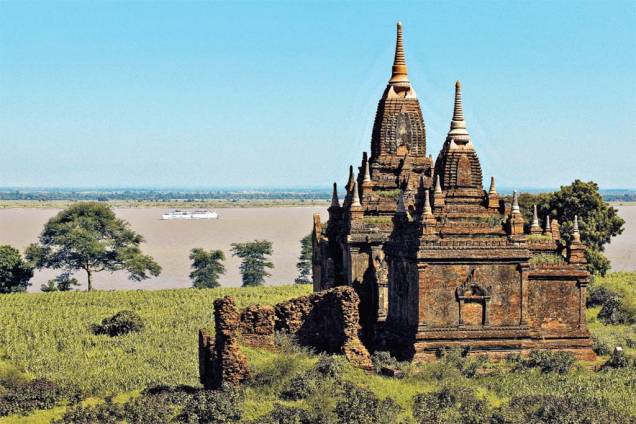 Um dos templos de <a href="https://viajeaqui.abril.com.br/cidades/mianmar-bagan" rel="Bagan" target="_blank">Bagan</a> e o barco The Road to Mandalay, no rio Ayeyarwady, ao fundo Um dos templos de <a href="https://viajeaqui.abril.com.br/cidades/mianmar-bagan" rel="Bagan" target="_blank">Bagan</a> e o barco The Road to Mandalay, no rio Ayeyarwady, ao fundo