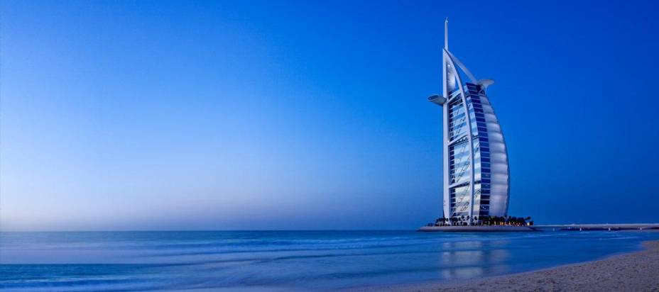 Hotel Burj Al Arab, com <a href="https://viajeaqui.abril.com.br/cidades/emirados-arabes-unidos-dubai" rel="Dubai" target="_blank">Dubai</a> ao fundo