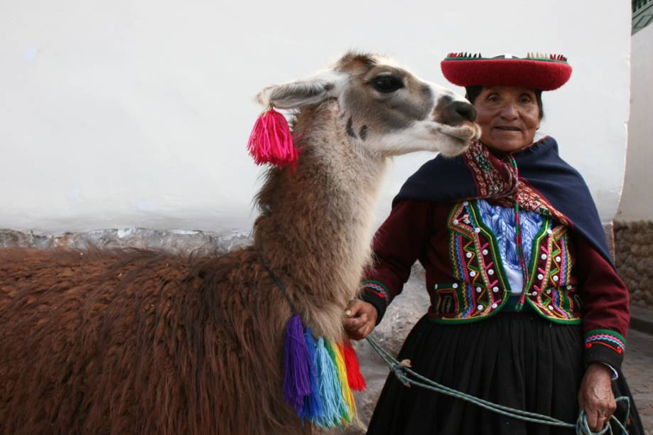 Mulher com trajes típicos do Peru com uma lhama