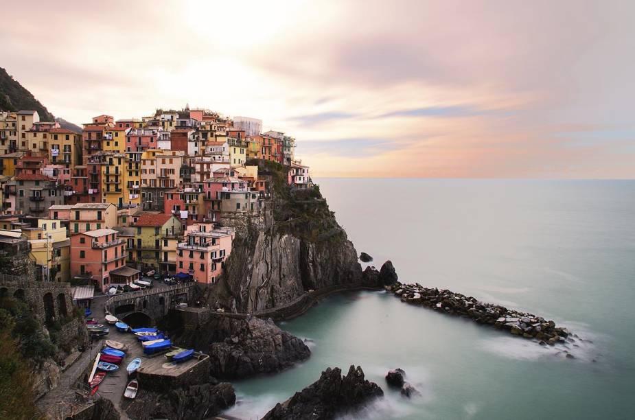 O dia amanhece em Manarola, uma das cidades mais icônicas do <a href="https://viajeaqui.abril.com.br/cidades/italia-cinque-terre" rel="Cinque Terre" target="_blank">Cinque Terre</a>