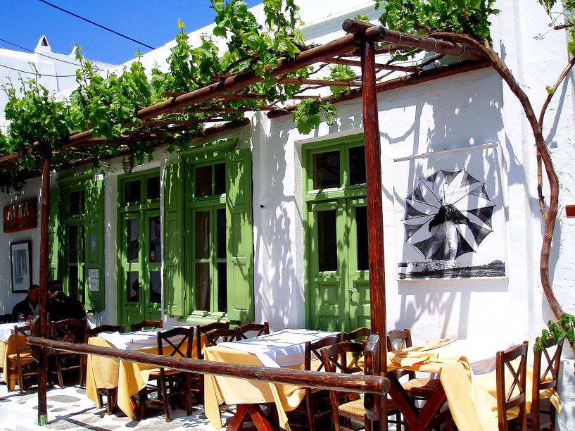 Um pequeno e charmoso café em Mykonos, uma das ilhas cíclades Um pequeno e charmoso café em Mykonos, uma das ilhas cíclades