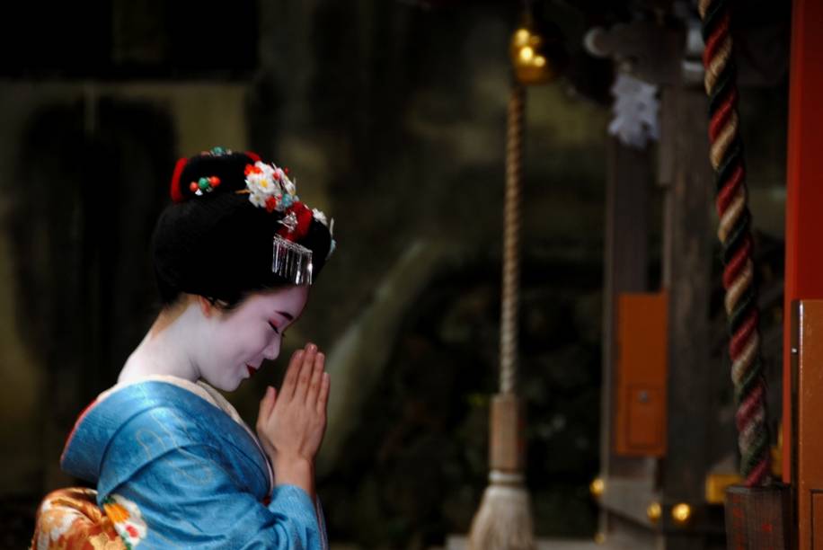 Aprendiz de geisha, conhecidas como maiko, faz oração no santuário xintoísta Matsuo Taisha, em Kyoto Aprendiz de geisha, conhecidas como maiko, faz oração no santuário xintoísta Matsuo Taisha, em Kyoto
