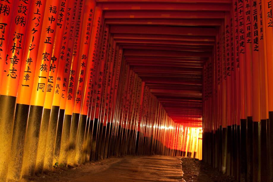 Uma das principais e mais chamativas características do Fushimi Inari Taisha é uma sequência interminável de portões <em>torii</em> Uma das principais e mais chamativas características do Fushimi Inari Taisha é uma sequência interminável de portões <em>torii</em>