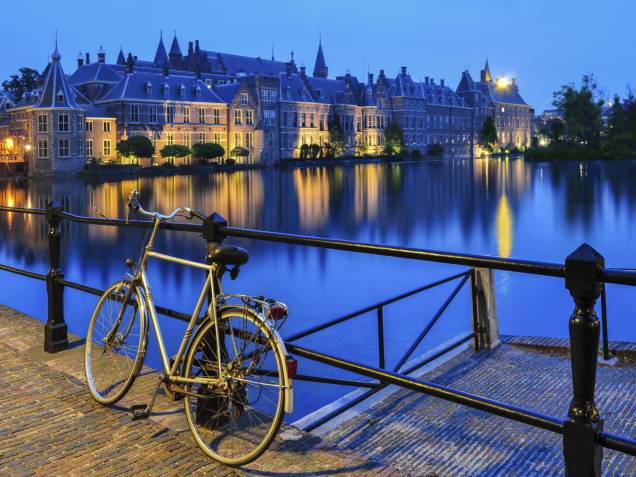 Os canais de Haia formam um cenário único e charmoso, perfeito para os passeios de bicicleta que formam a identidade dos holandeses. Ao fundo, a beleza do Binnenhof Palace Os canais de Haia formam um cenário único e charmoso, perfeito para os passeios de bicicleta que formam a identidade dos holandeses. Ao fundo, a beleza do Binnenhof Palace