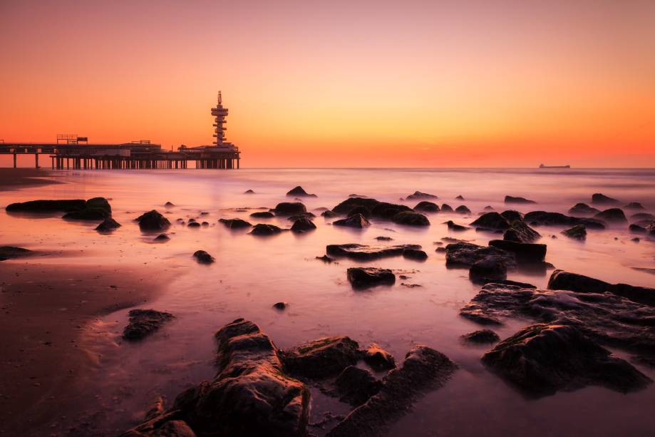 O bairro de Scheveningen, em Haia, é marcado por uma bela praia, onde moradores e visitantes se encontram para praticar esportes como kitesurf e windsurf. Rochas compõem o cenário do litoral e marcam uma bela paisagem