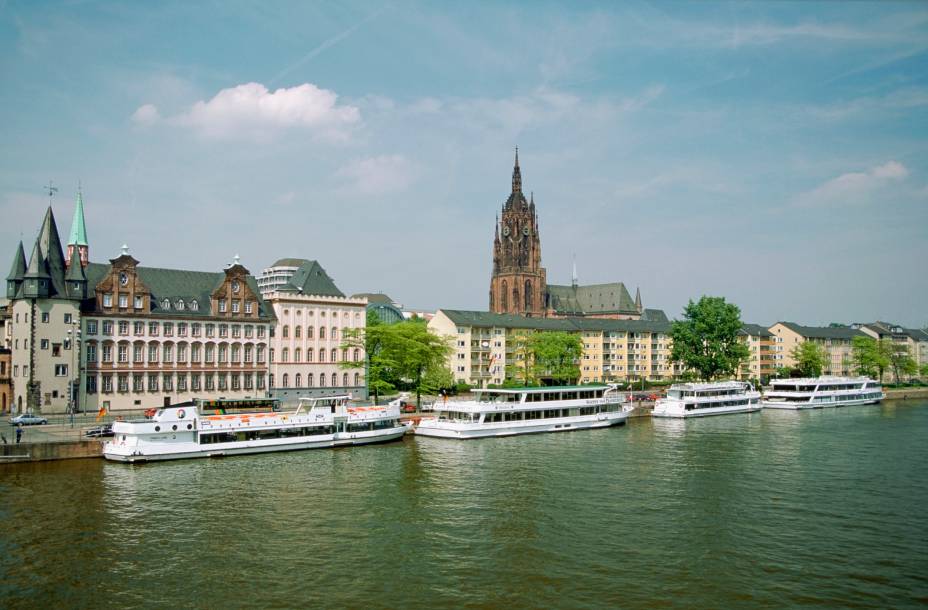 Barcos se acumulam ao longo do lago principal da cidade de Frankfurt. Ao fundo, a beleza da Catedral de São Bartholomeu 