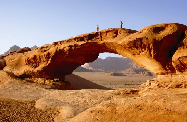 Ponte natural de pedra no deserto jordaniano de Wadi Rum; dá pra circular neste cenário do além em carros 4x4 ou pernoitar em um acampamento pra fazer uma imersão completa na cultura da região, experiências sempre capitaneadas pelos beduínos que moram na aldeia local Ponte natural de pedra no deserto jordaniano de Wadi Rum; dá pra circular neste cenário do além em carros 4x4 ou pernoitar em um acampamento pra fazer uma imersão completa na cultura da região, experiências sempre capitaneadas pelos beduínos que moram na aldeia local