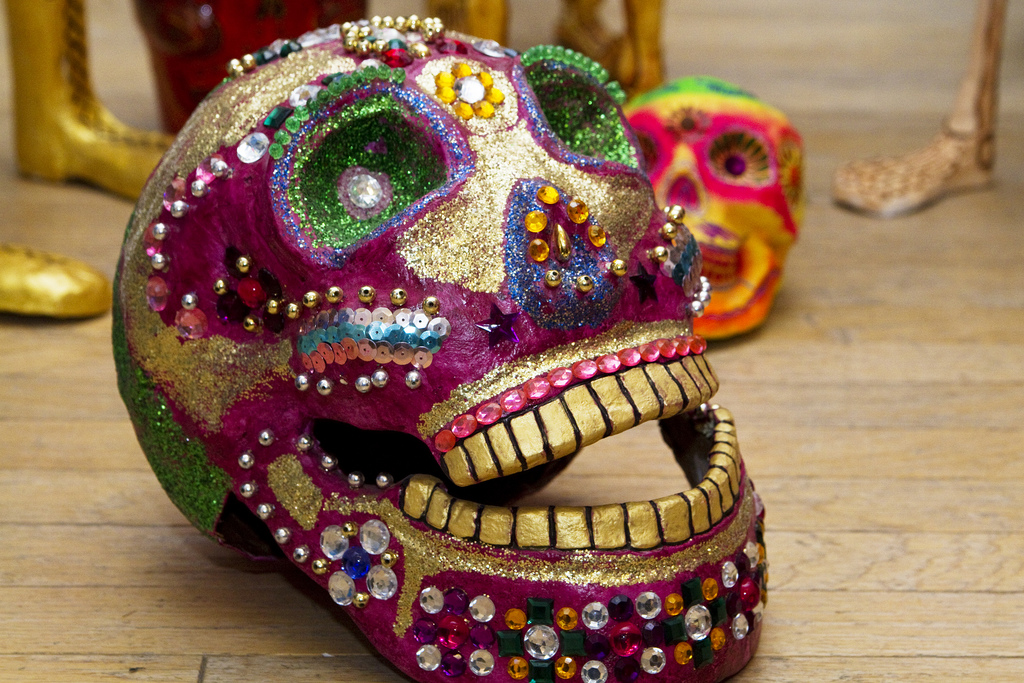Caveira artesanal coberta em tintura, lantejoulas e brilhos, formando a tradicional pintura do D&iacute;a de los Muertos