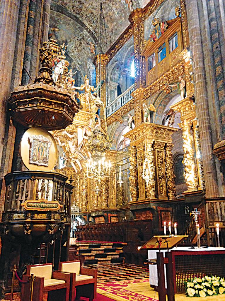 Catedral de Santiago de Compostela, Espanha, Santiago de Compostela Interior de uma catedral, com tetos altos, pisos de ladrilho de diferentes padrões e grupos de pequenas colunas suportando a estrutura, assim como pinturas e estátuas de santos e madonas, grande parte em ouro.