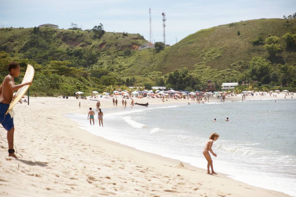 Criança entra no mar da praia de Peruíbe, em Barra do Una, litoral do estado de São Paulo