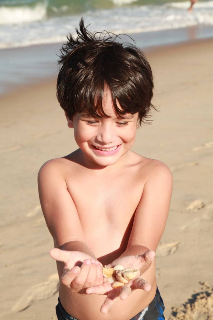 Garoto colhe conchas na Praia do Futuro, Fortaleza, Ceará