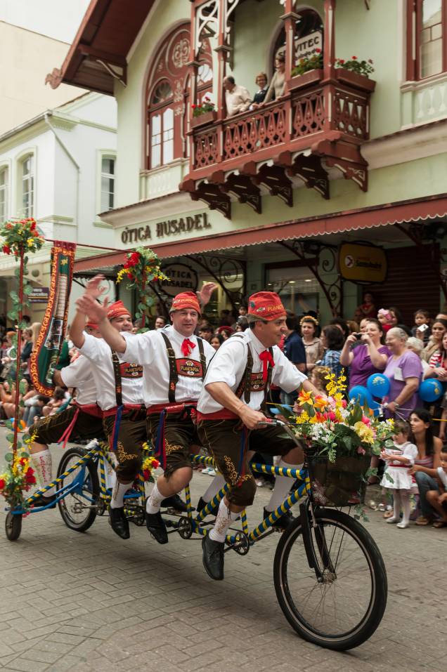 Grupo de amigos em uma bicicleta compartilhada durante uma evento de rua em Blumenau Grupo de amigos em uma bicicleta compartilhada durante uma evento de rua em Blumenau