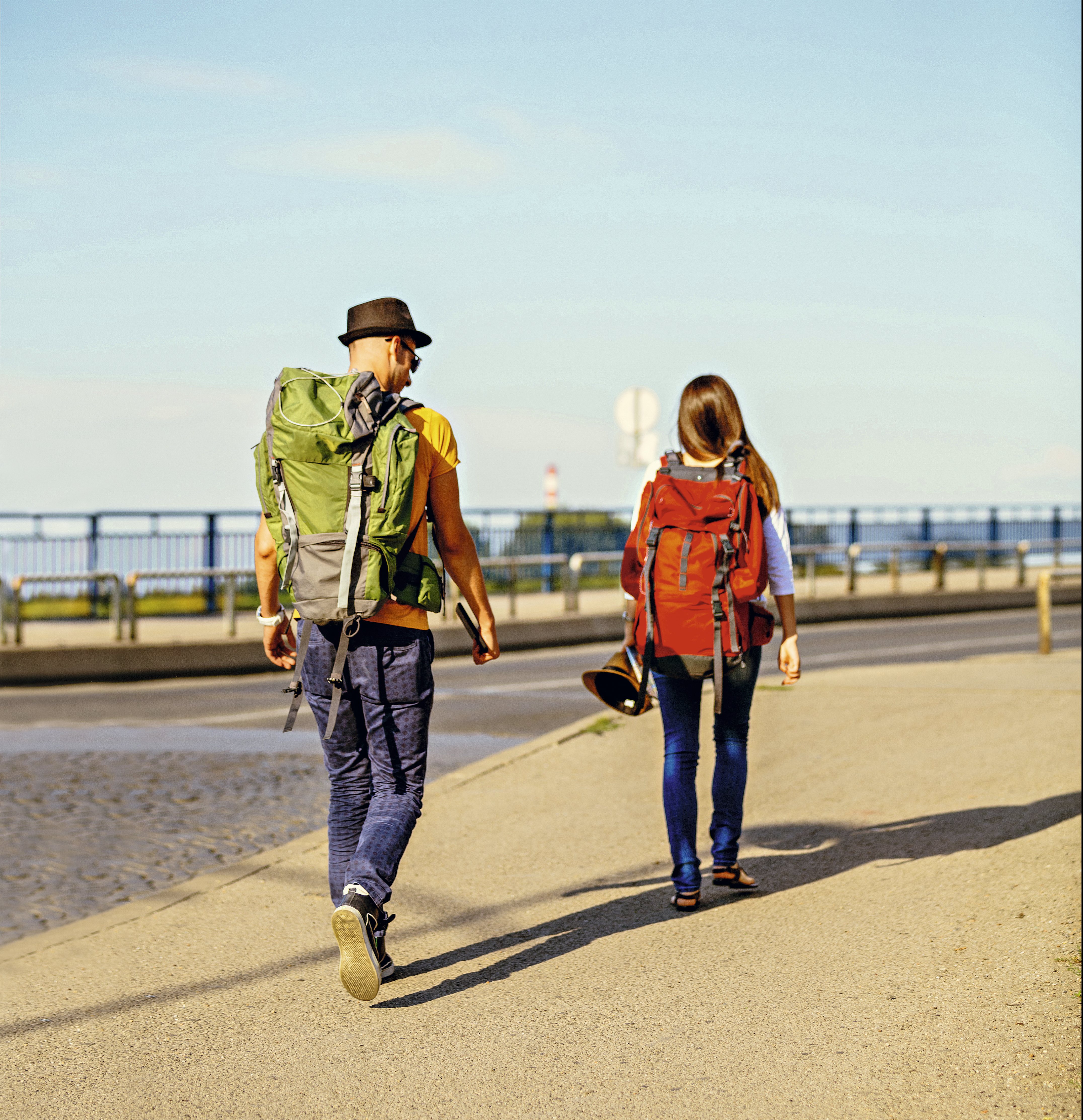 Duas pessoas andando com mochila nas costas
