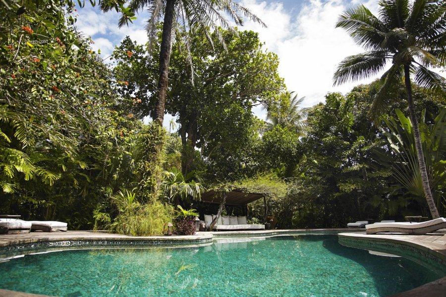 A piscina de quartzo verde é cercada por um jardim exuberante. A piscina de quartzo verde é cercada por um jardim exuberante.