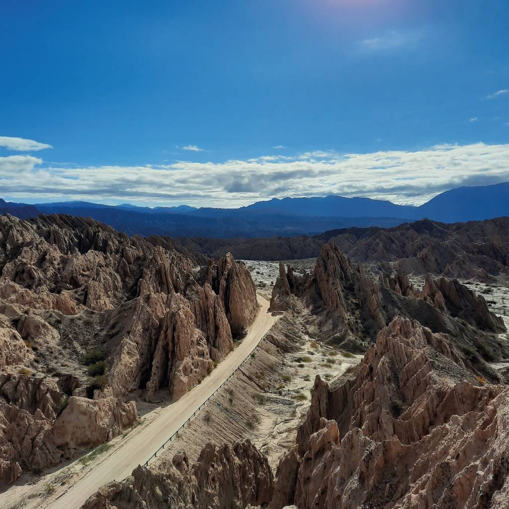 Quebrada de las flechas A imagem mostra uma estrada passando pelo meio de uma formação rochosa que parece apontar para o céu.