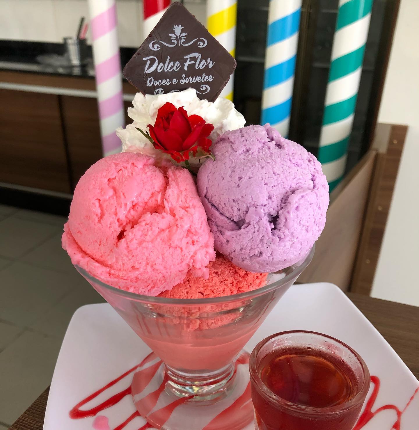Sorvete de flores imagem mostra uma taça com bolas de sorvete rosa, branco e roxo.