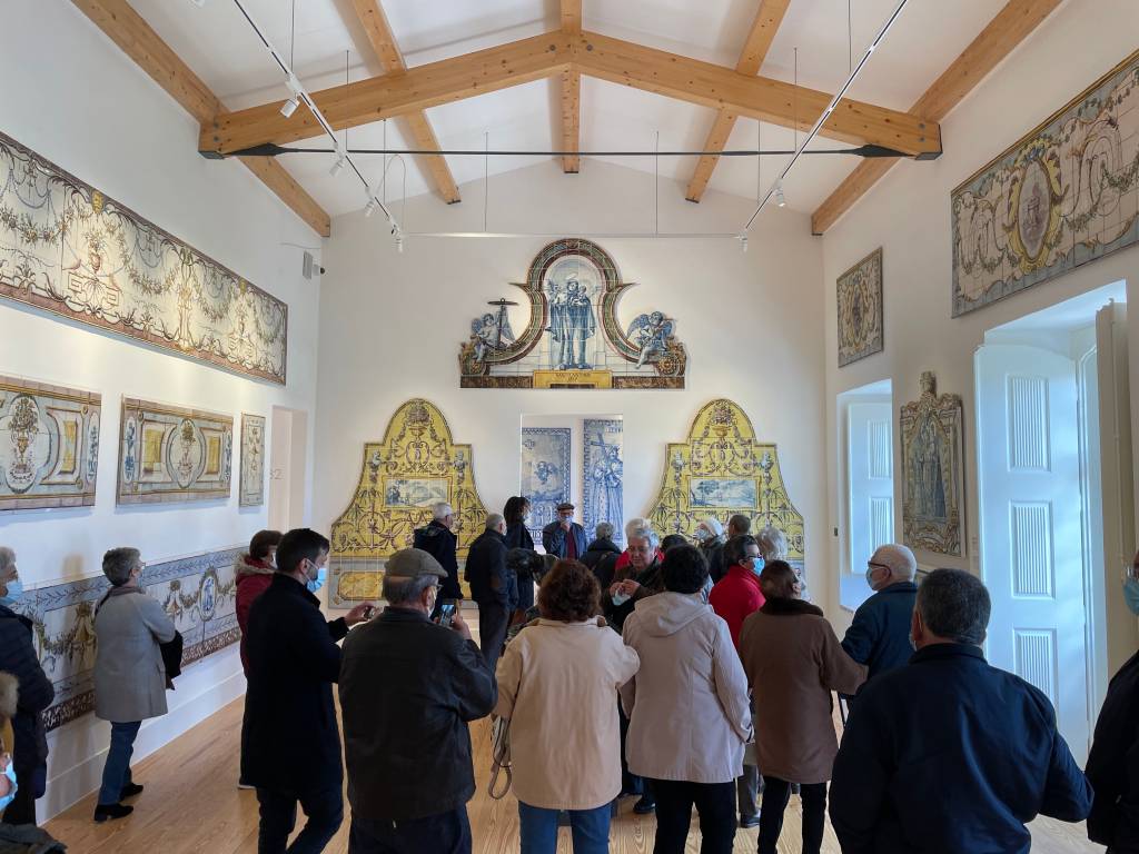 IMG_2591 Um grupo de pessoas observa alguns painéis de azulejo nas paredes de um museu