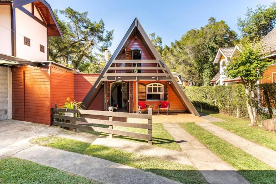 A fotografia colorida mostra uma casinha triangular de madeira