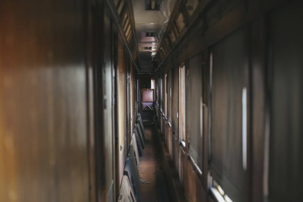 Corredores do Orient Express A imagem mostra um corredor escuro com paredes de madeira