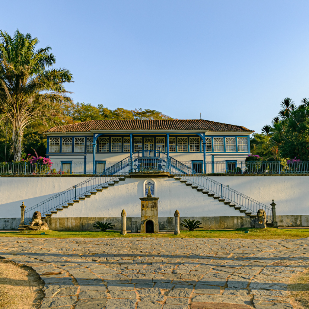 FazendaSãoLuizdaBoaSorte_CasaSede_Foto_Divulgação A imagem é uma fazenda antiga branca e azul