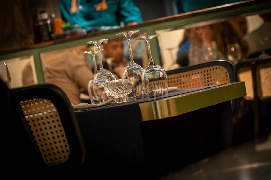 5 Mesa de um restaurante com cadeiras de palhinha e copos virados de cabeça para baixo
