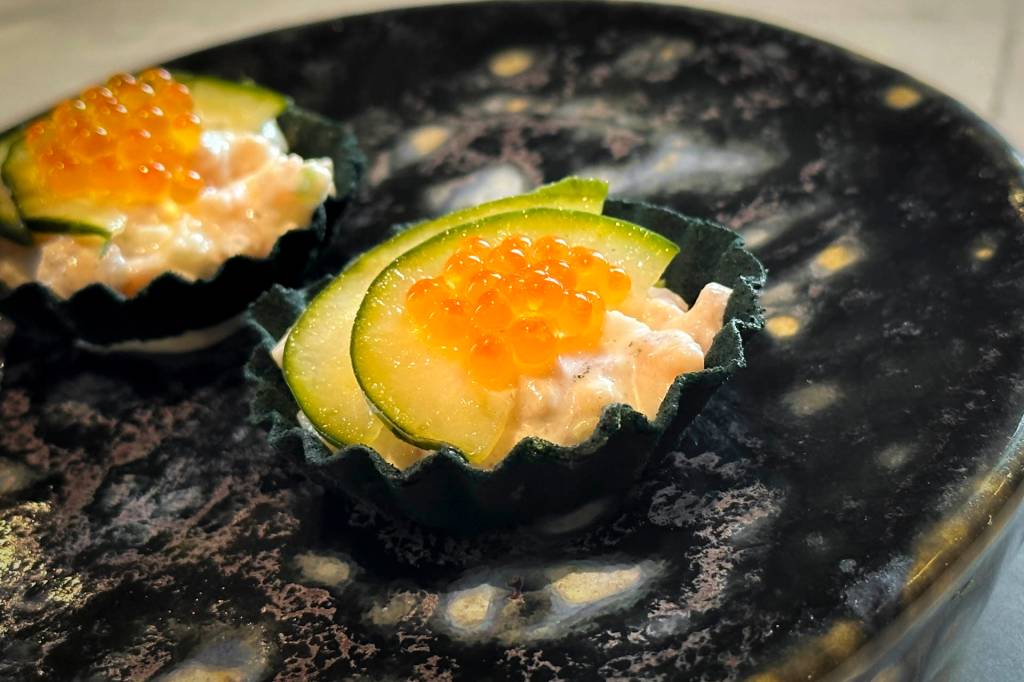 Pequenas tortinhas com a massa verde de algas, coroadas por ovas laranja de peixe