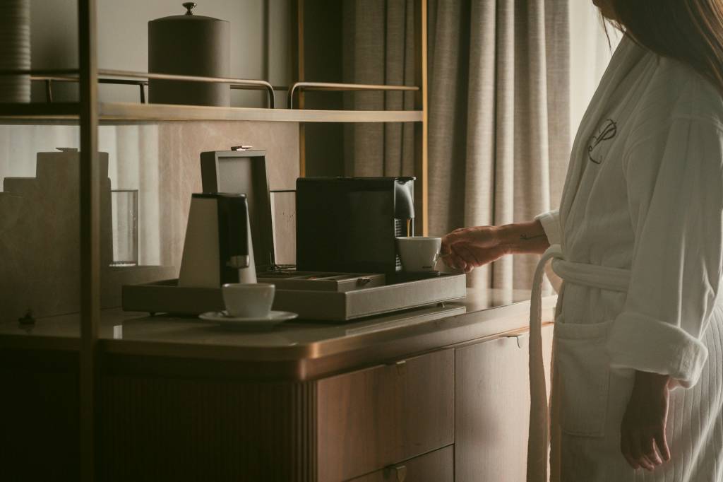 Detalhe do quarto, com uma pessoa fazendo um café